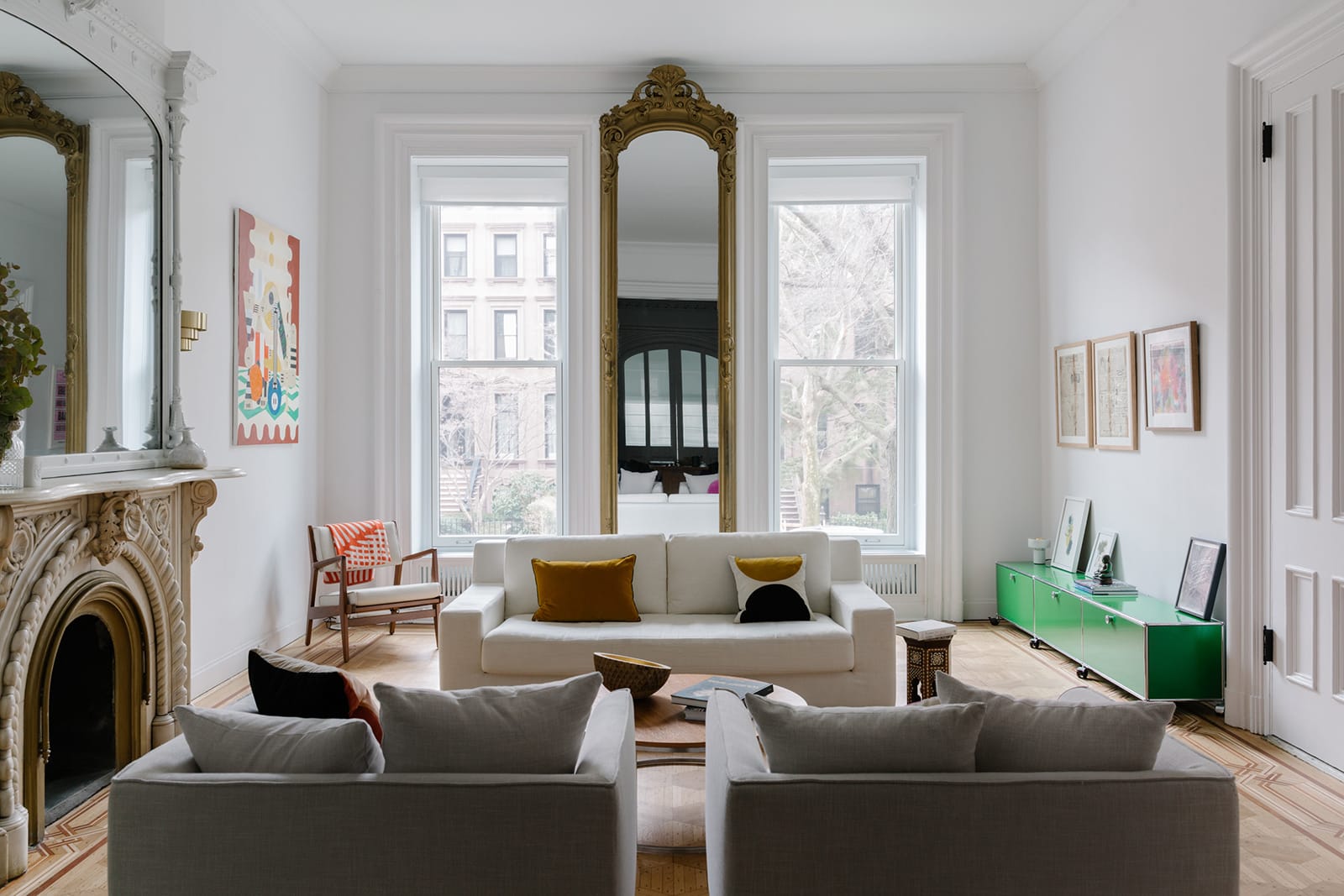 a parlor with white walls, a marble mantel and a pier mirror