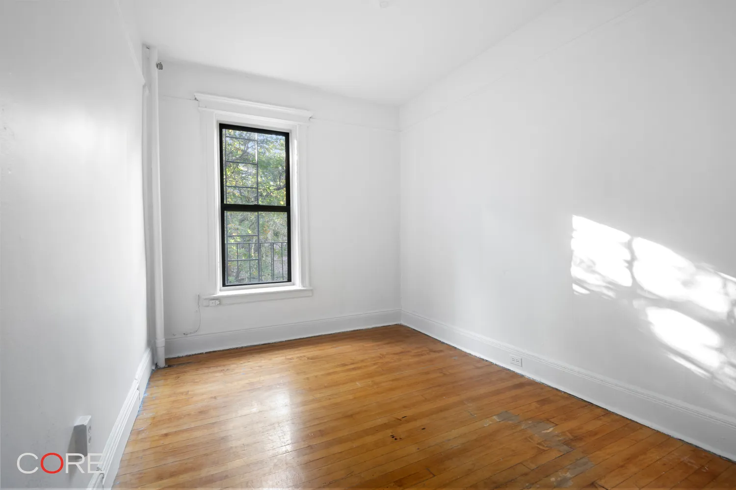 bedroom with one window and wood floor