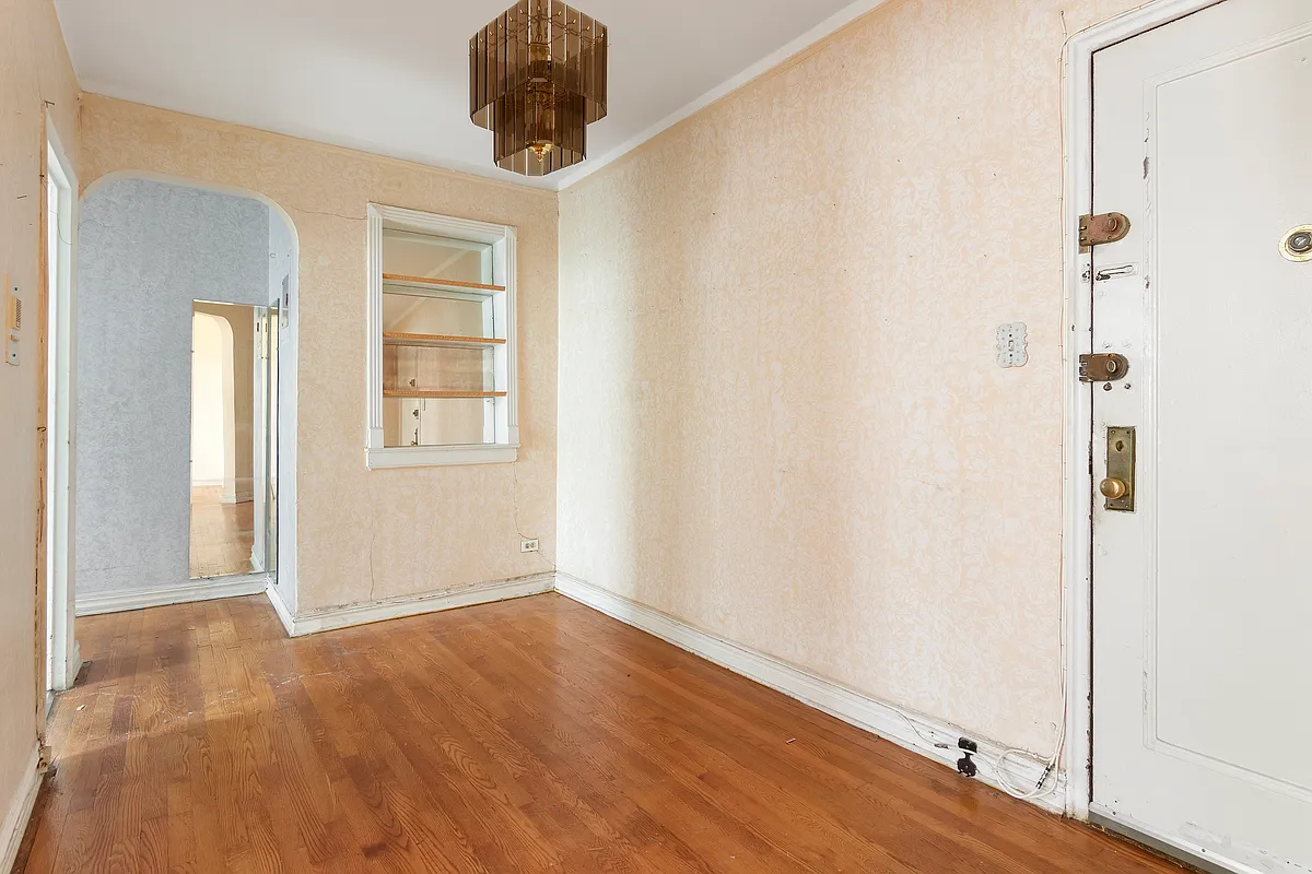 entry foyer with mirrored niche with shelves, wood floor, arched doorway to hallway