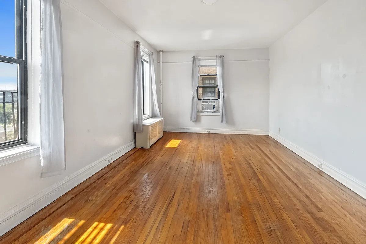 bedroom with two exposures, wood floor, picture rail on two walls