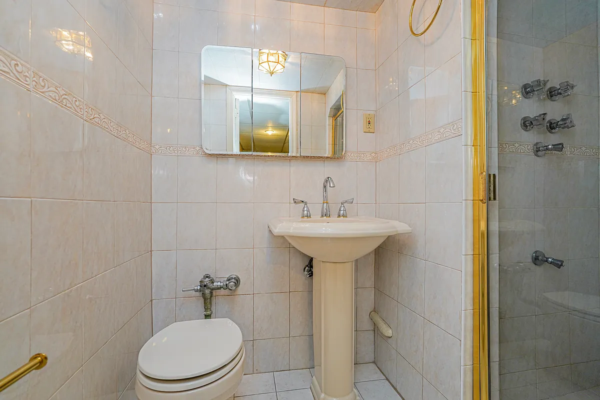 garden level bathroom with beige tile and a built-in shower