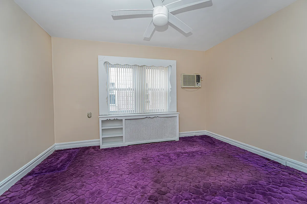bedroom with ceiling fan and purple wall-to-wall carpet
