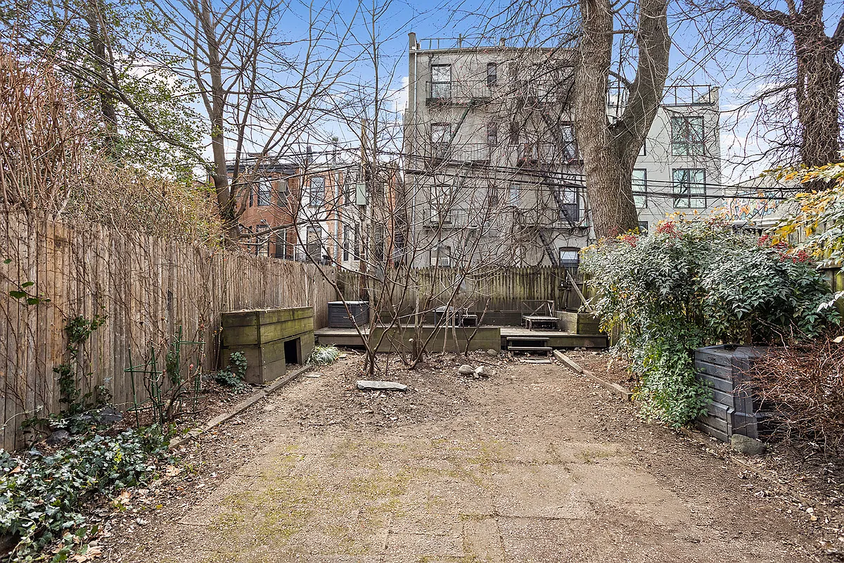 rear yard with planting beds on the side and a raised platform at the rear