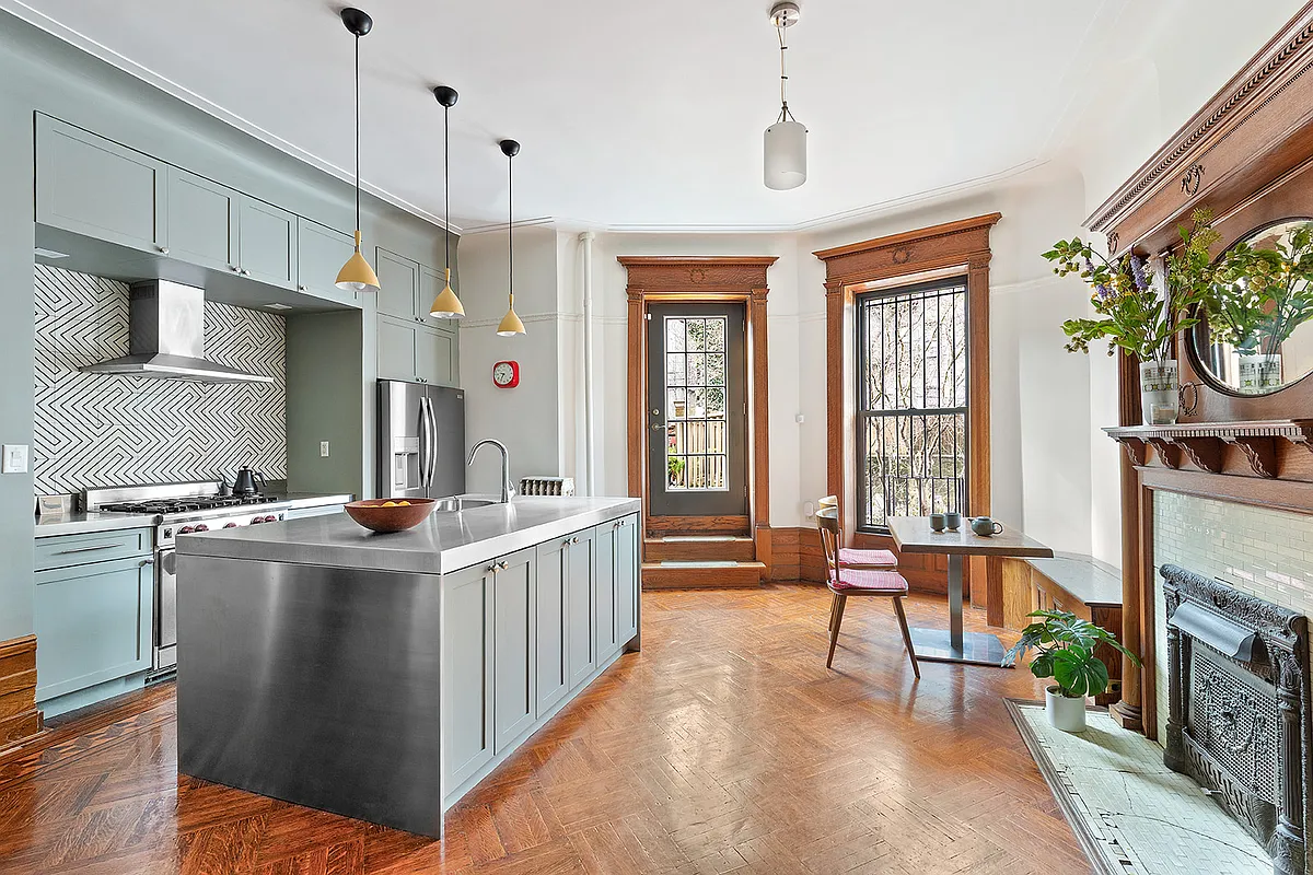 parlor level kitchen with blue cabinets, mantel, door to deck