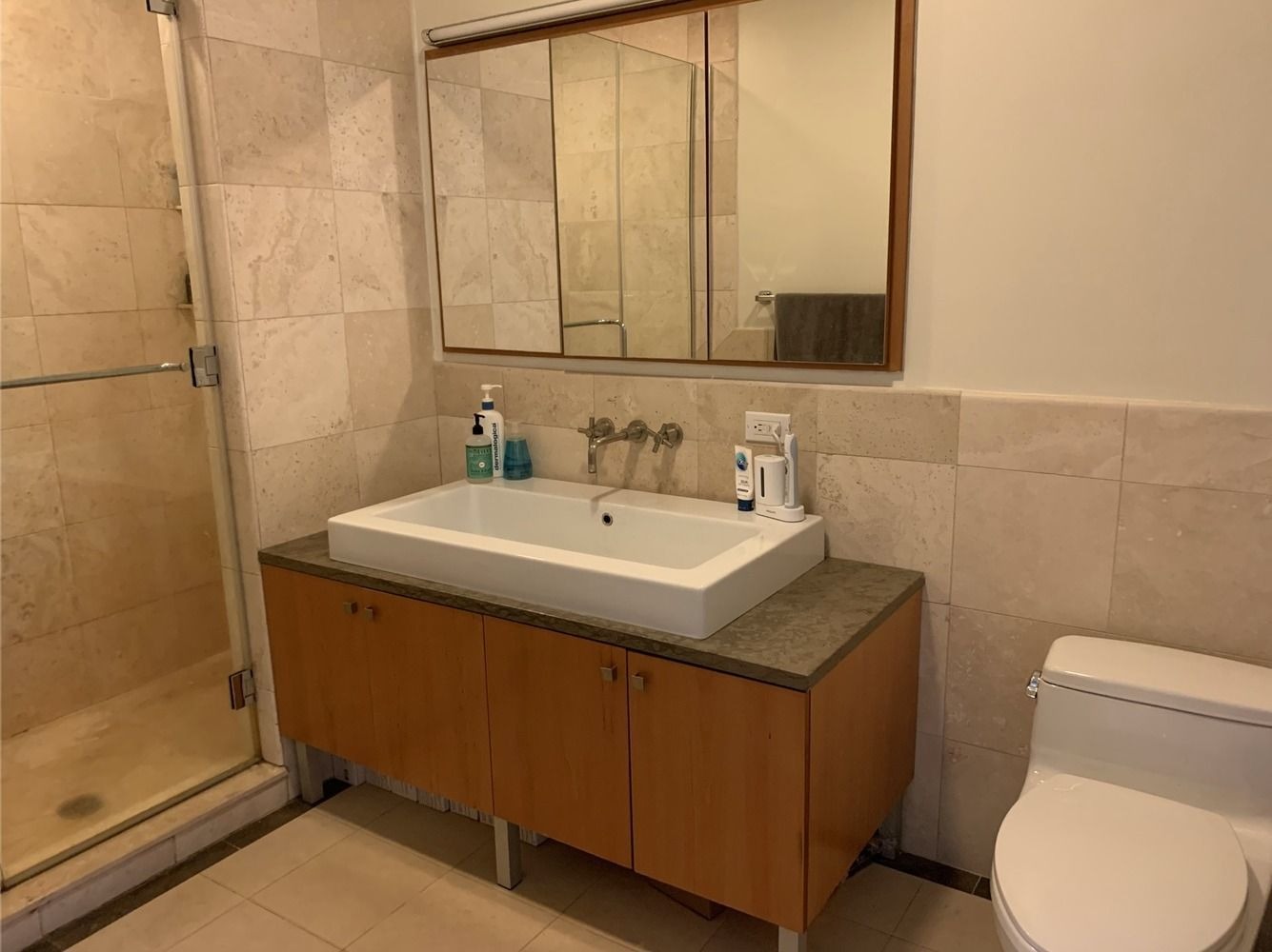 bathroom with shower, beige tiles