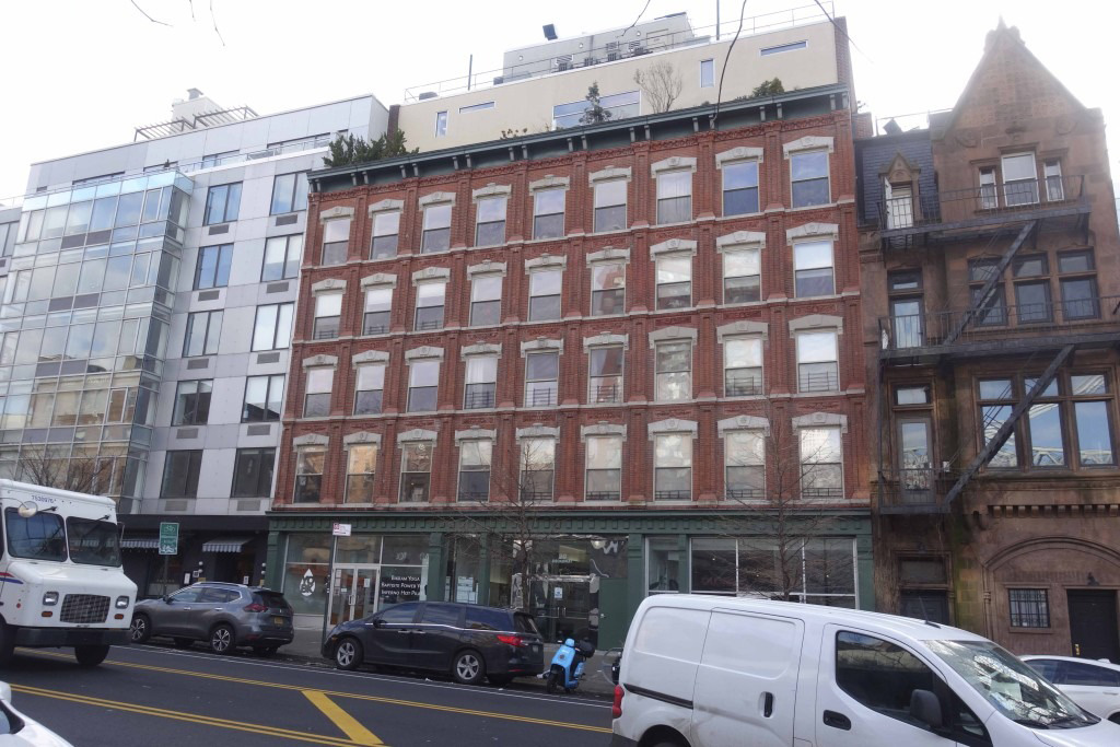 view of the brick building with modern upper floors