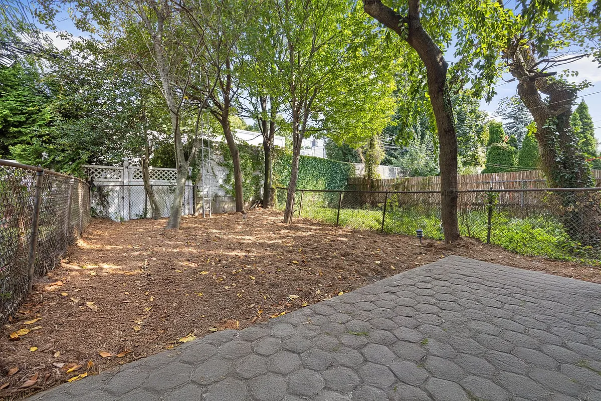rear yard with paved patio and grassless area with trees