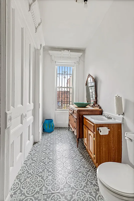 bathroom with graphic tile floor, white painted trim