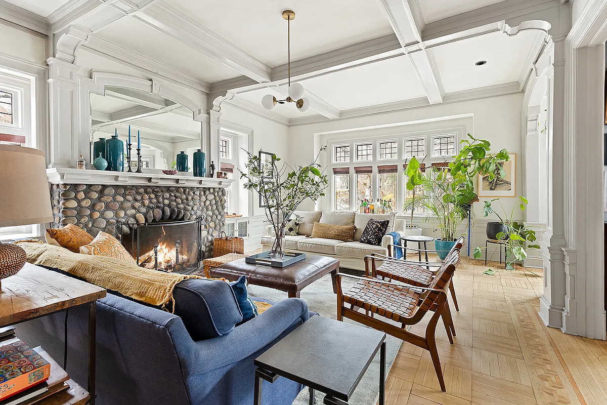 living room with a stone fireplace, beamed ceiling