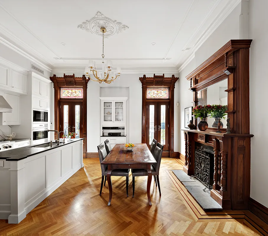 kitchen with white cabinets and a center island along with original moldings, stained glass, mantel