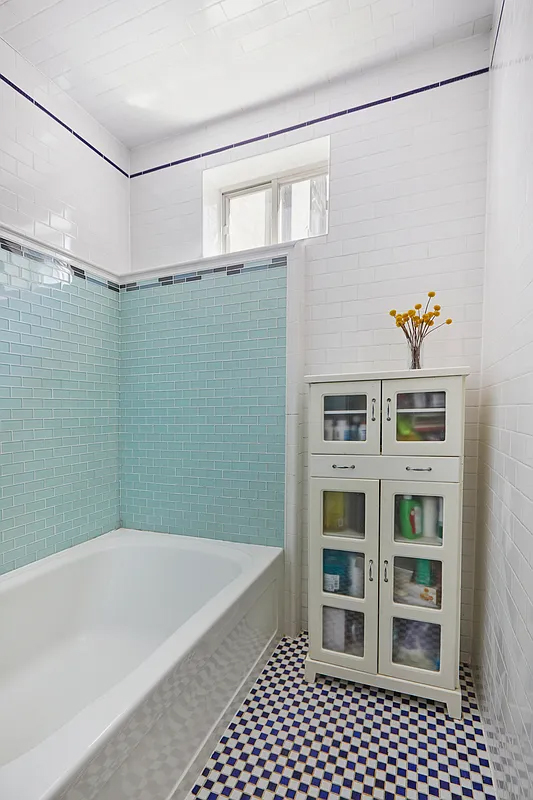 bathroom with blue tile around tub